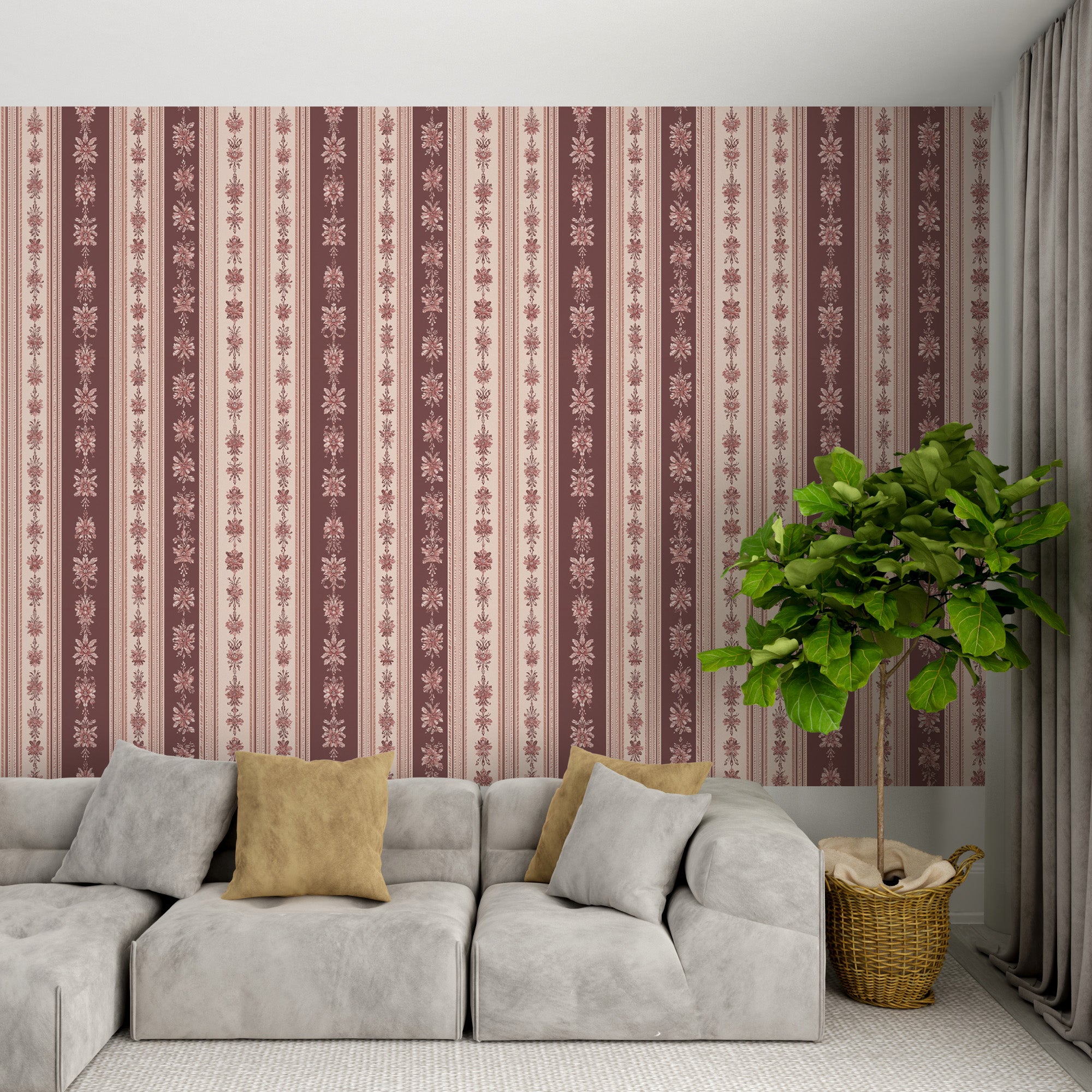 Vintage floral striped wallpaper in dusty rose and cream with damask motifs behind a light gray sectional and green plant