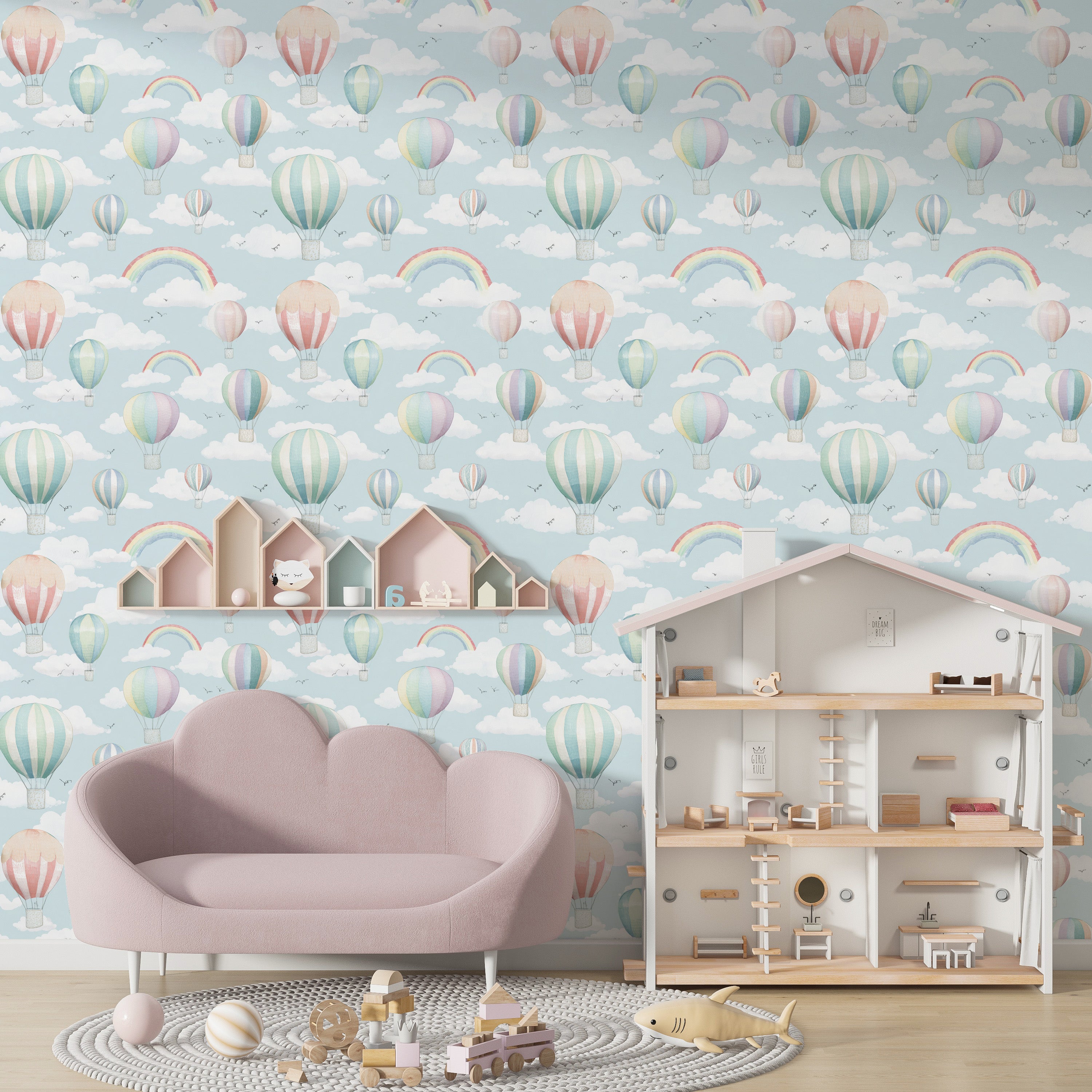 Whimsical pastel blue nursery wall with hot air balloon wallpaper full of clouds rainbows in a child’s playroom