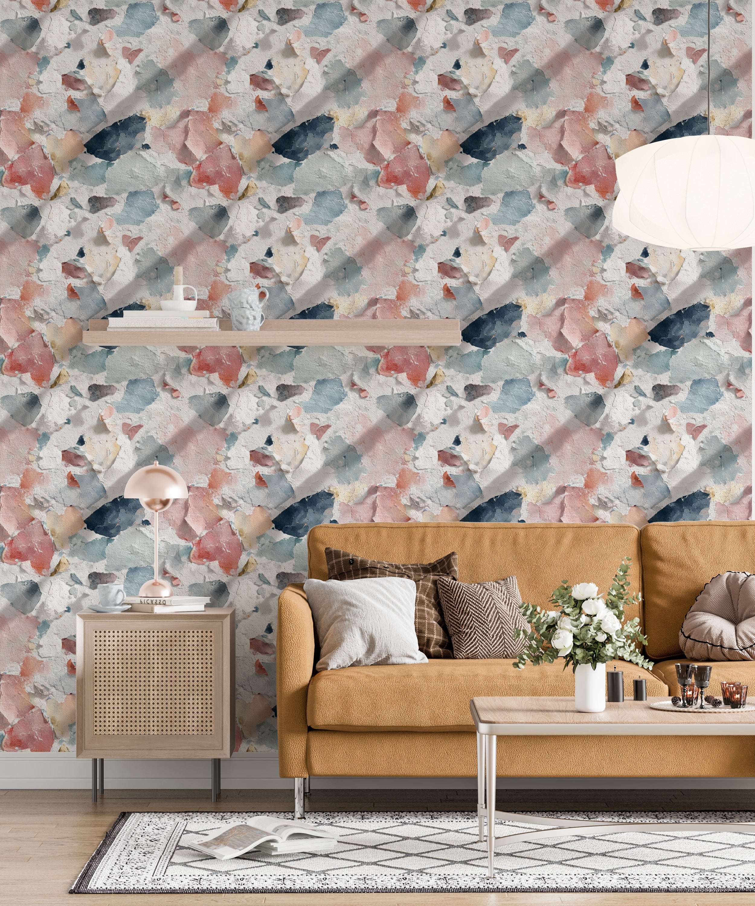 Distressed paint wallpaper in coral blue cream navy tones on a living room wall with a tan sofa, coffee table