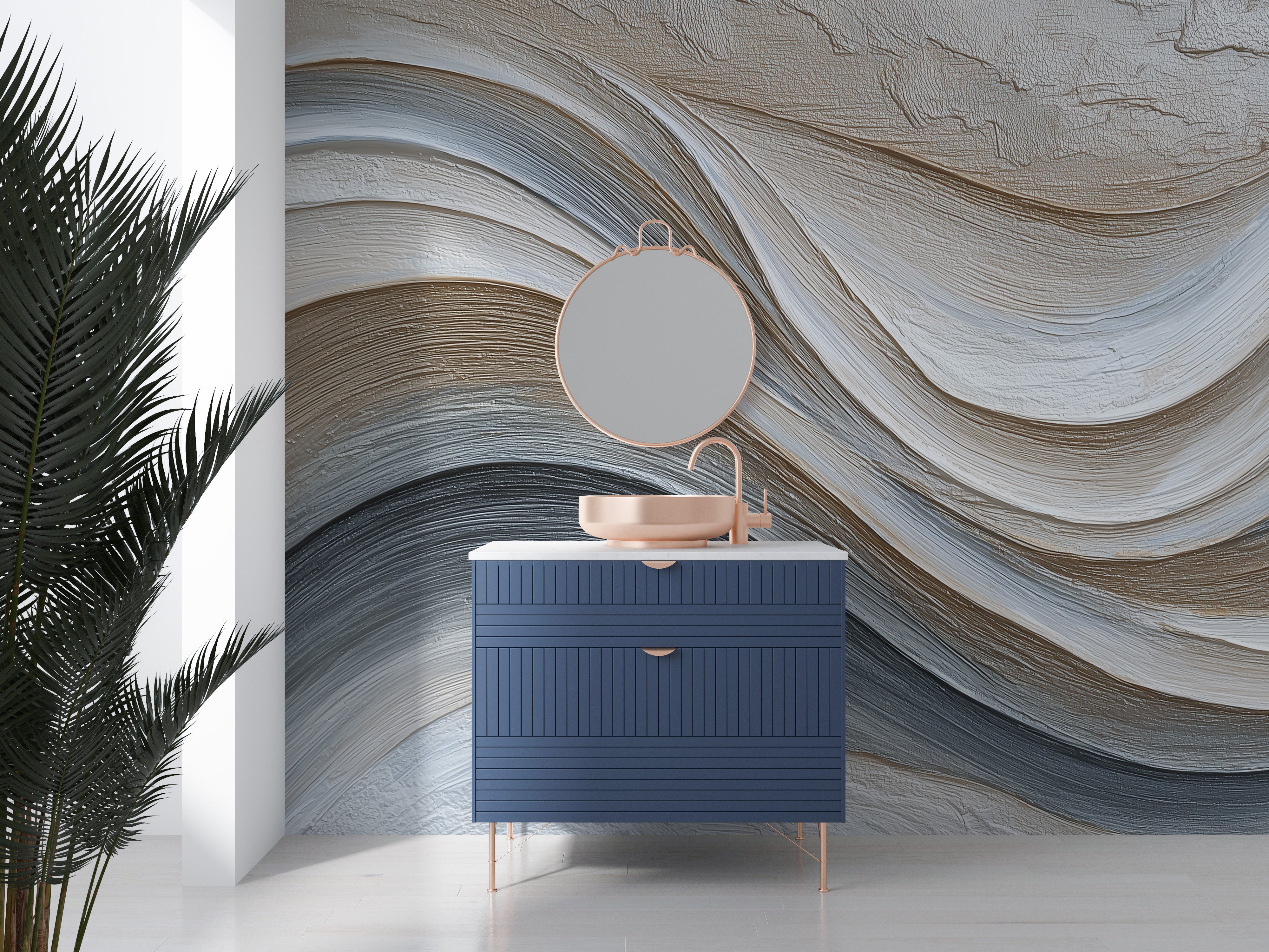 Abstract flowing waves mural in grey beige tones behind a modern blue vanity with circular rose gold mirror and sink, bedroom